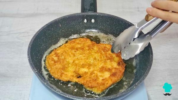 Receta de Pollo a la parmesana: crujiente por fuera, jugoso por dentro y con mucho queso fundido - Paso 7