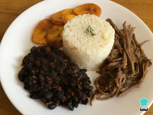 Pabellón Criollo: Plato nacional compuesto por arroz blanco, carne desmechada, caraotas negras y tajadas de plátano maduro.